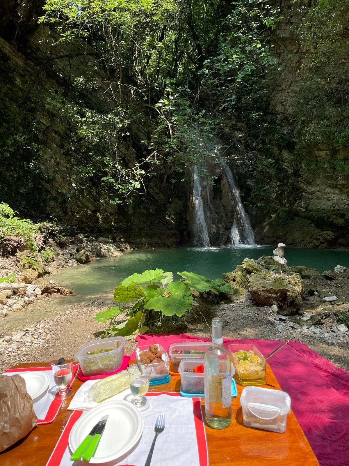 Il tavolo apparecchiato per un picnic davanti alla cascata